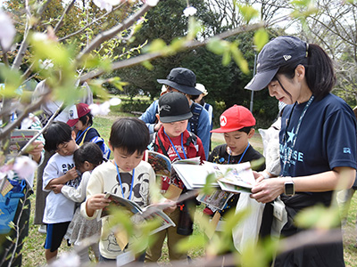 マップを手に植物を観察する子どもたち