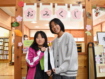 おみくじと記念撮影をする姉妹