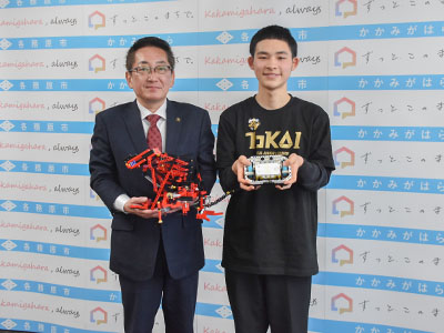 制作したロボットを持ち、浅野市長と並んで記念撮影を受ける原田さんの写真